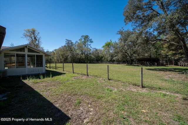 view of yard featuring a sunroom, fence, and central AC unit