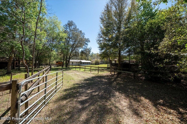 view of yard with a rural view and fence