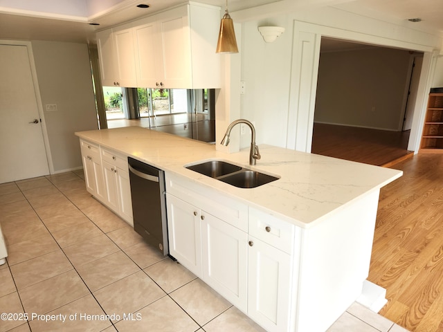 7106 Green Abbey Way, Spring Hill, FL 34606 - kitchen with dishwashing machine, a sink, white cabinets, light stone counters, and decorative light fixtures
