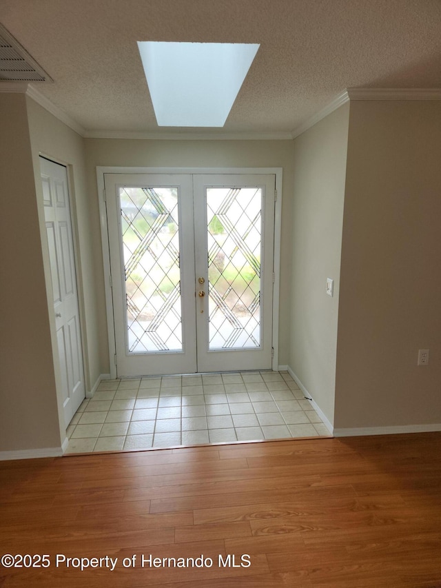7106 Green Abbey Way, Spring Hill, FL 34606 - doorway to outside featuring light wood-style flooring, french doors, ornamental molding, a textured ceiling, and baseboards