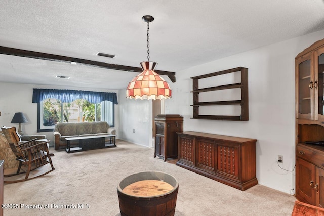 carpeted living area with visible vents, beamed ceiling, and a textured ceiling