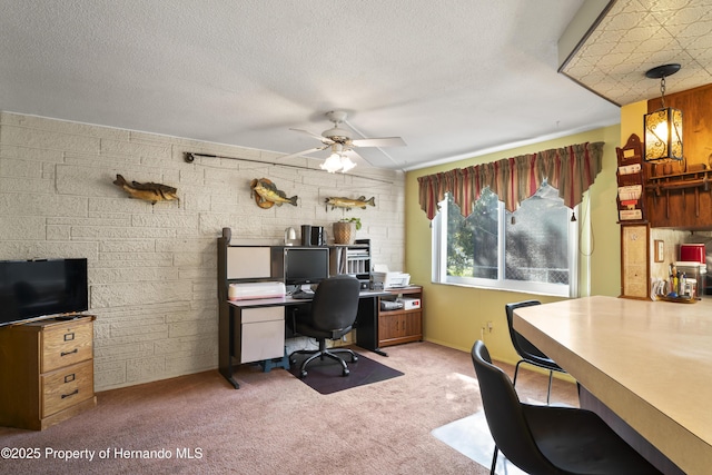 home office featuring carpet floors, ceiling fan, and a textured ceiling