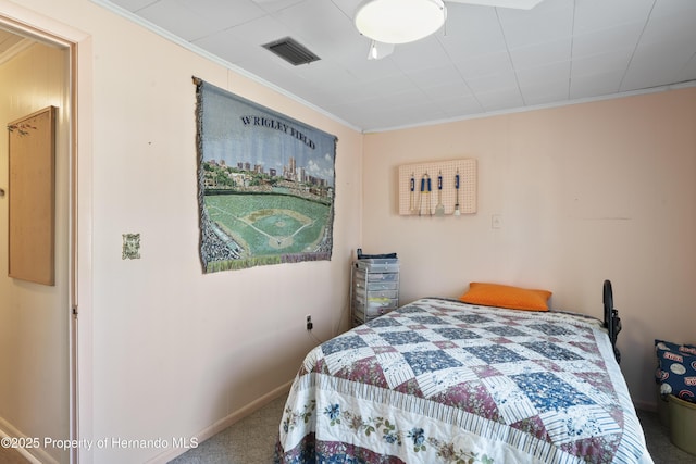 carpeted bedroom featuring baseboards, visible vents, and ornamental molding