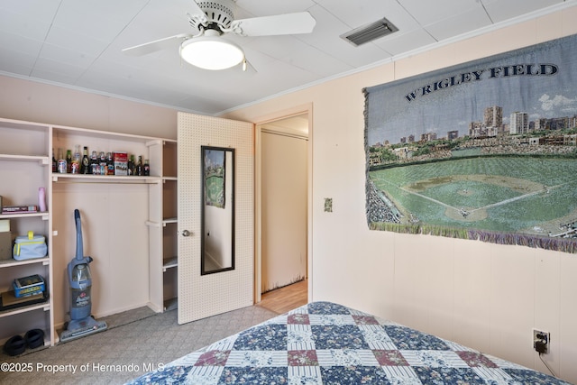 bedroom with a ceiling fan, visible vents, and crown molding