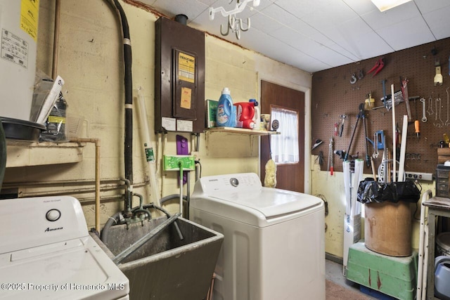 clothes washing area with laundry area, washer and clothes dryer, a sink, electric panel, and a workshop area