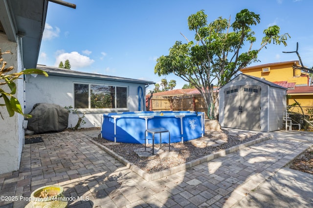 view of pool featuring a storage shed, a fenced in pool, an outbuilding, a grill, and fence