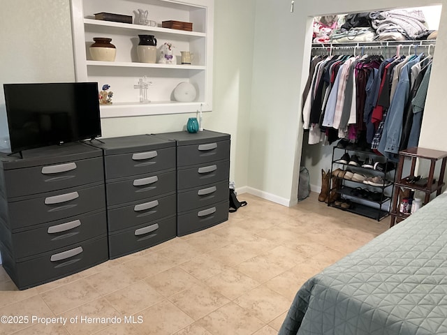 bedroom with a closet, baseboards, and light tile patterned floors