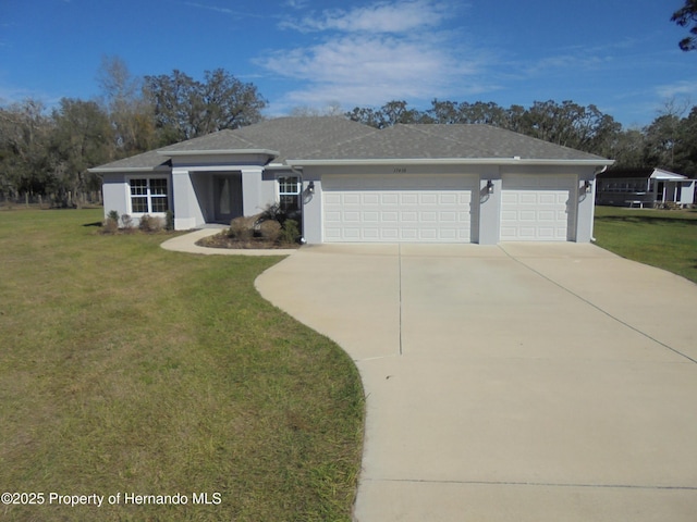 view of front facade featuring an attached garage, driveway, a front yard, and stucco siding