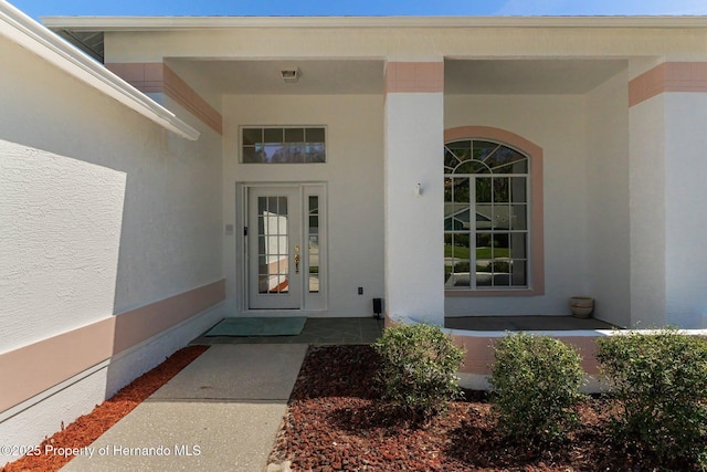 entrance to property featuring stucco siding