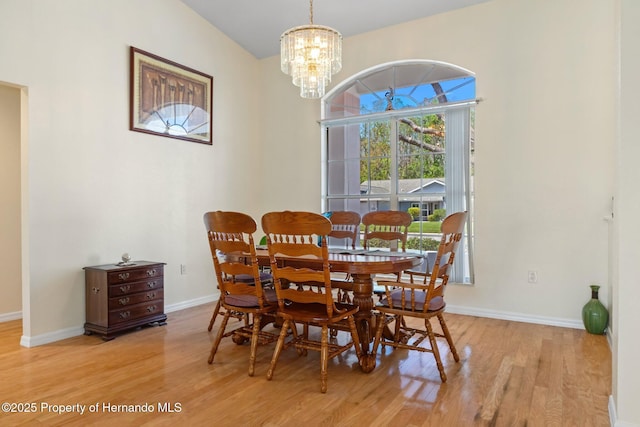 dining room featuring baseboards, a notable chandelier, and light wood-style floors