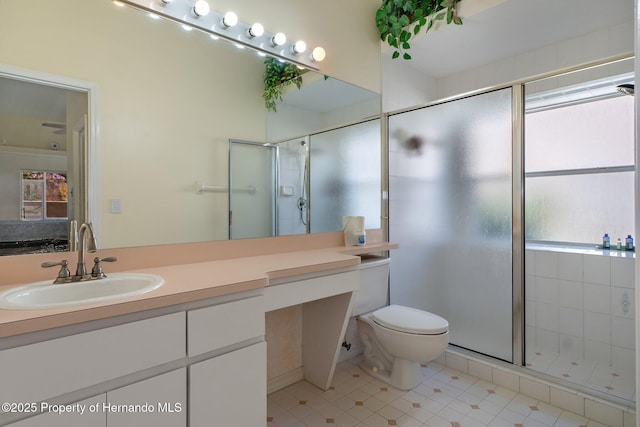 bathroom with a shower with shower door, vanity, and toilet