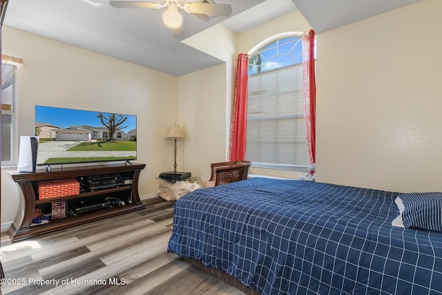 bedroom with wood finished floors, a ceiling fan, and baseboards