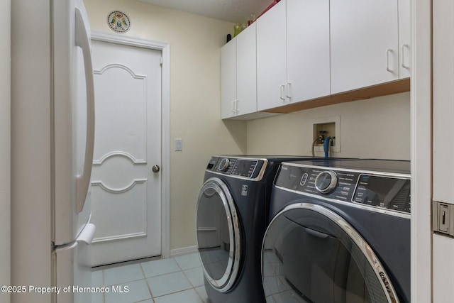 laundry room with cabinet space, tile patterned floors, baseboards, and independent washer and dryer