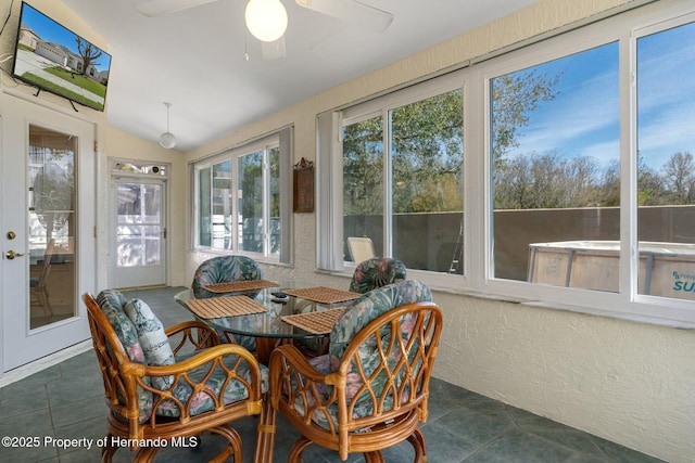 sunroom featuring lofted ceiling and ceiling fan