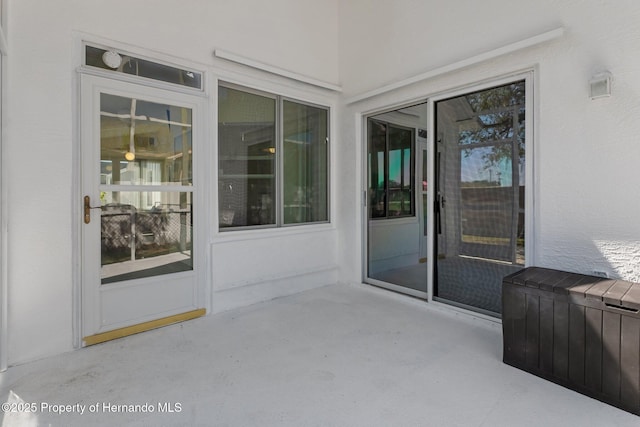 entrance to property featuring a patio area and stucco siding