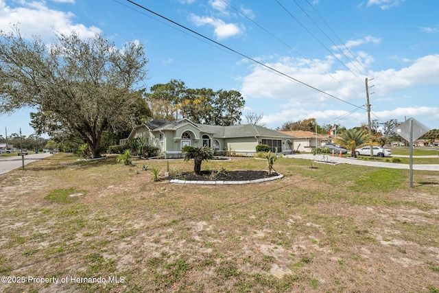 ranch-style house with concrete driveway and a front lawn