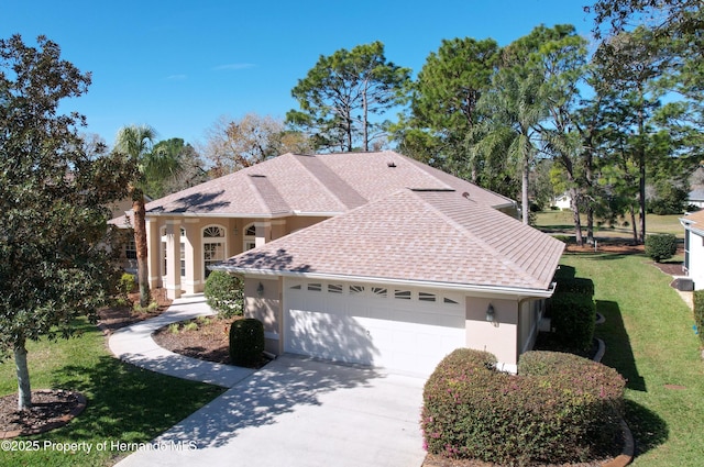 view of front of house with stucco siding, a shingled roof, an attached garage, driveway, and a front lawn