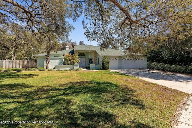 ranch-style house featuring stucco siding, fence, a garage, driveway, and a front lawn