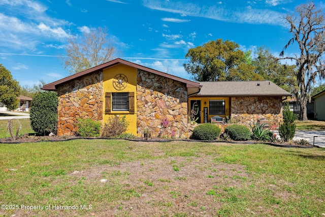 mid-century home with stone siding and a front lawn