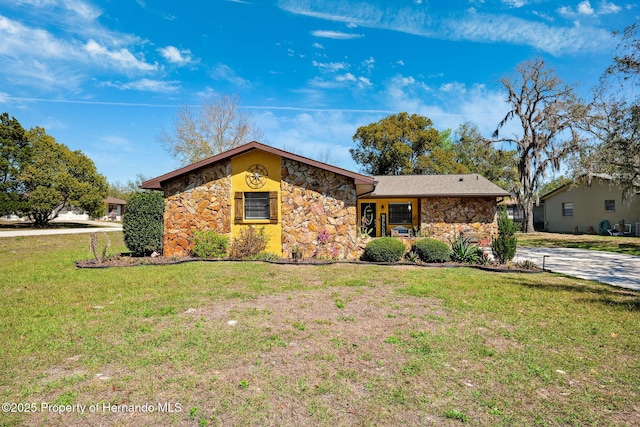 mid-century modern home featuring stone siding and a front lawn