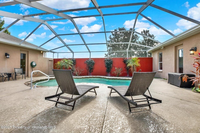 pool featuring glass enclosure and a patio