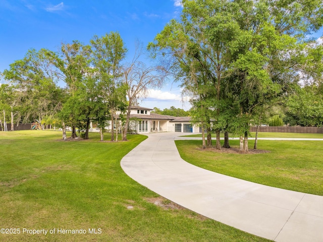 view of front of property featuring a garage, driveway, and a front lawn