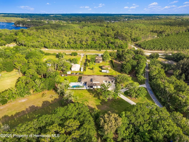 drone / aerial view with a water view and a forest view