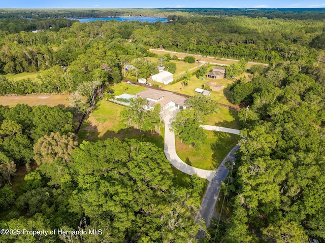 drone / aerial view with a water view and a wooded view