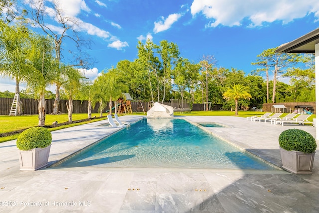 view of pool with a fenced in pool, a lawn, a fenced backyard, a patio area, and a playground