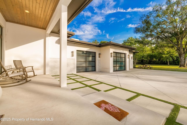 view of patio with a garage and concrete driveway