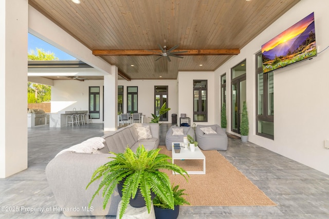 view of patio with exterior kitchen, ceiling fan, an outdoor living space, and grilling area