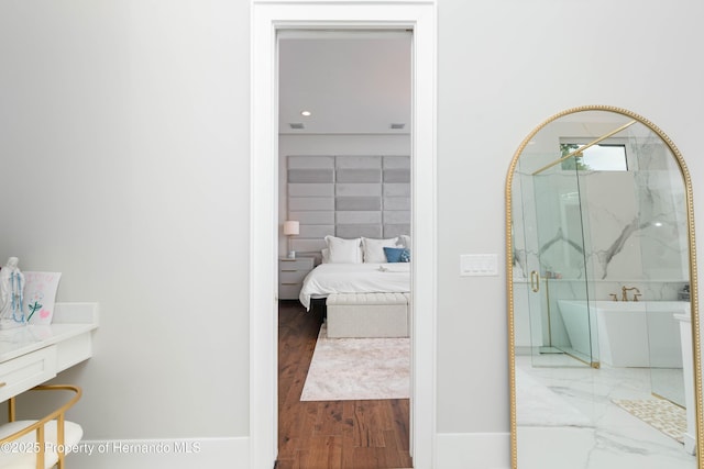 bedroom with wood finished floors and baseboards