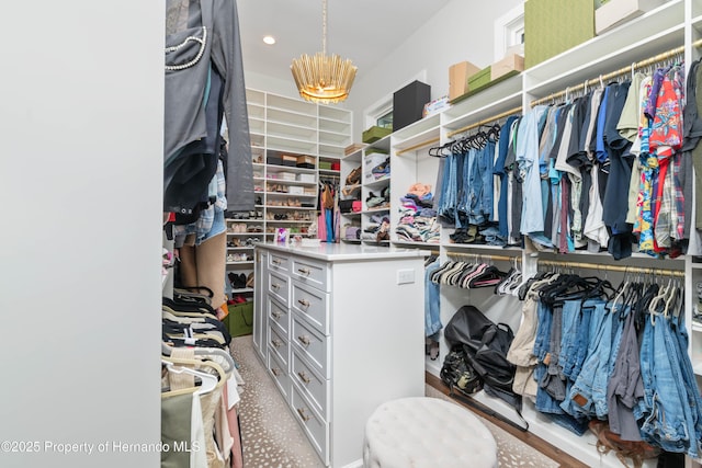 walk in closet featuring an inviting chandelier