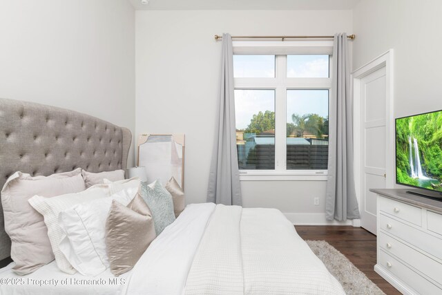 bedroom with dark wood-style floors and baseboards