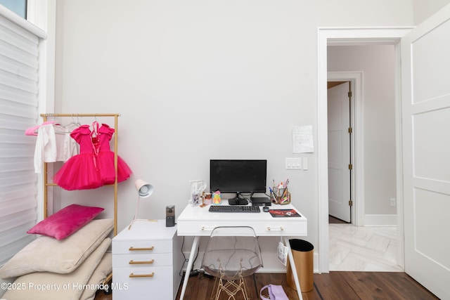 office space with baseboards and parquet flooring