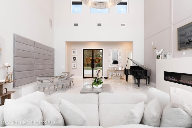 living room featuring a glass covered fireplace, visible vents, and plenty of natural light