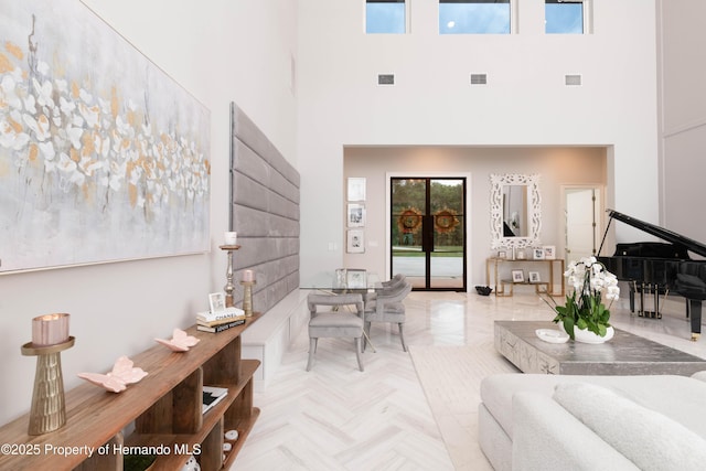 living room with a towering ceiling and visible vents