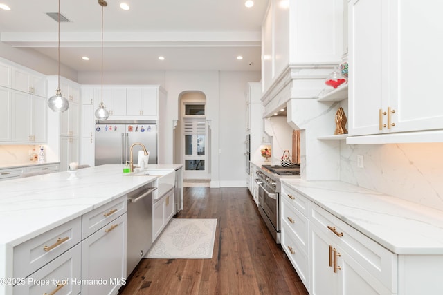 kitchen featuring dark wood-type flooring, a sink, high quality appliances, white cabinetry, and backsplash