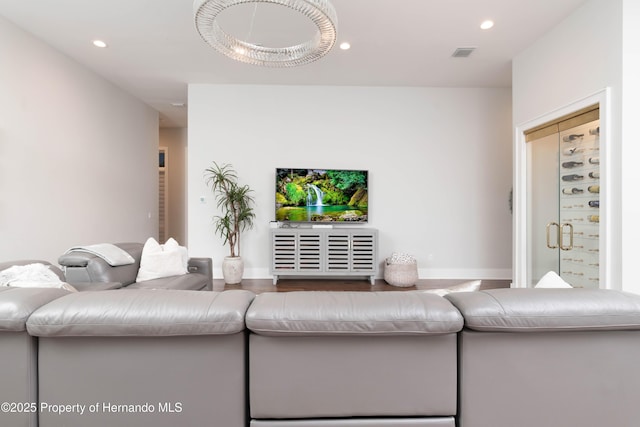 living room with baseboards, visible vents, wood finished floors, and recessed lighting