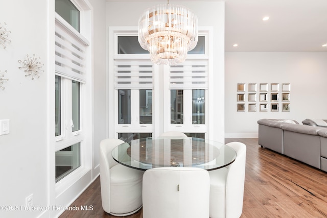 dining space with a chandelier, baseboards, wood finished floors, and recessed lighting