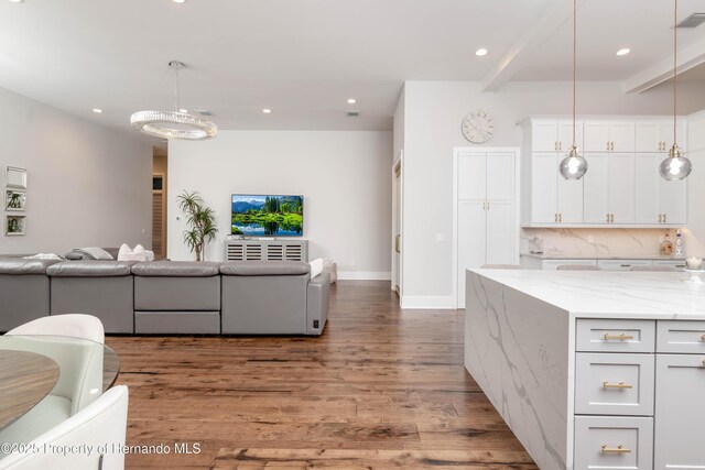 kitchen with light stone counters, recessed lighting, wood finished floors, white cabinetry, and open floor plan