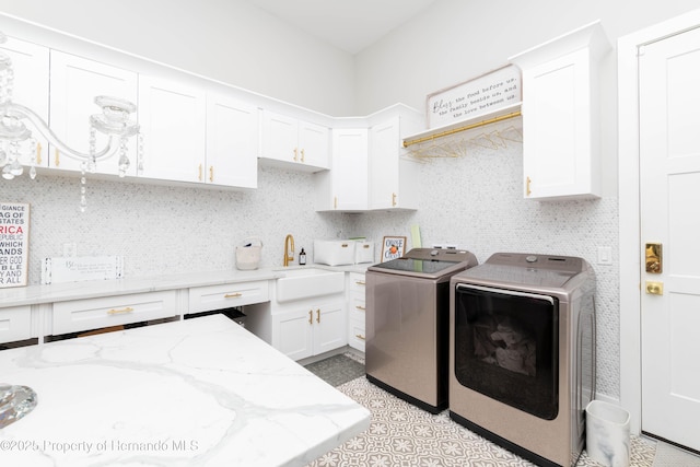 clothes washing area featuring cabinet space, a sink, and separate washer and dryer