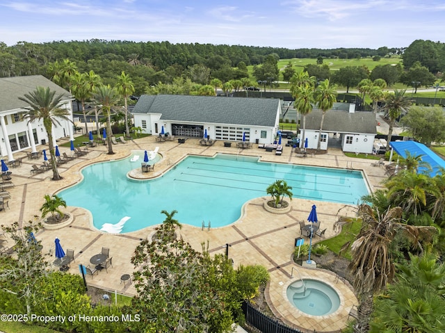 community pool featuring a community hot tub, fence, and a patio