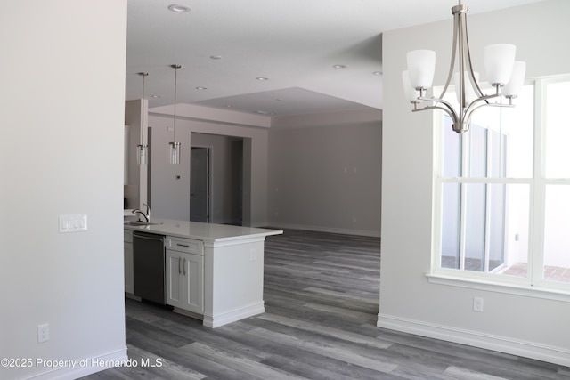 kitchen featuring a sink, pendant lighting, dishwasher, open floor plan, and an inviting chandelier