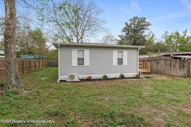 view of outdoor structure featuring ac unit and a fenced backyard