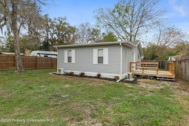 back of property with a lawn, a fenced backyard, and a wooden deck