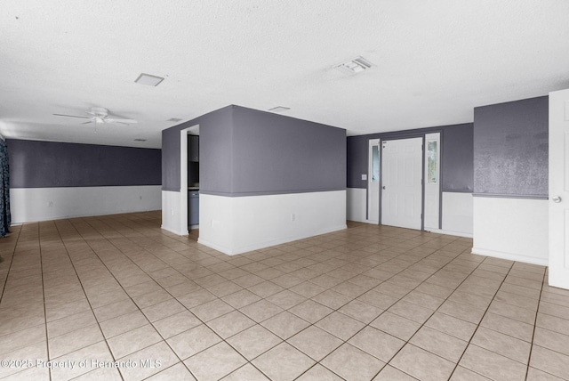 unfurnished room featuring a ceiling fan, visible vents, and a textured ceiling