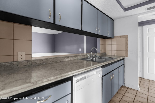 kitchen with visible vents, a sink, light tile patterned flooring, white dishwasher, and decorative backsplash