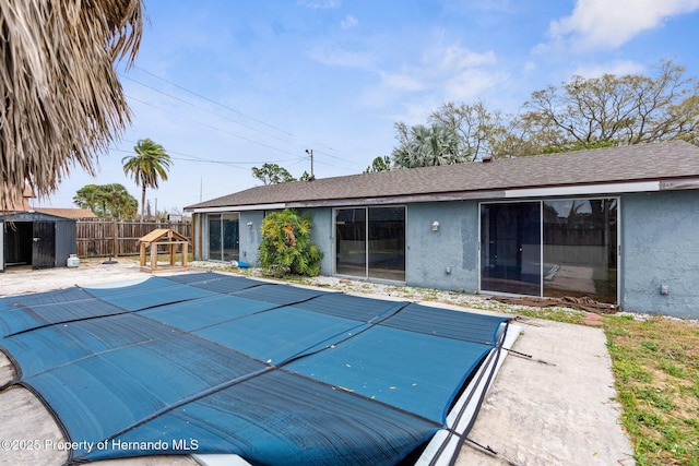 view of pool featuring an outdoor structure, a storage unit, fence, and a fenced in pool