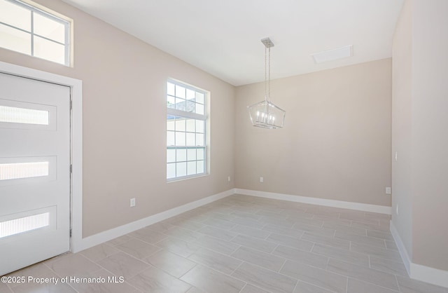 foyer featuring a notable chandelier and baseboards